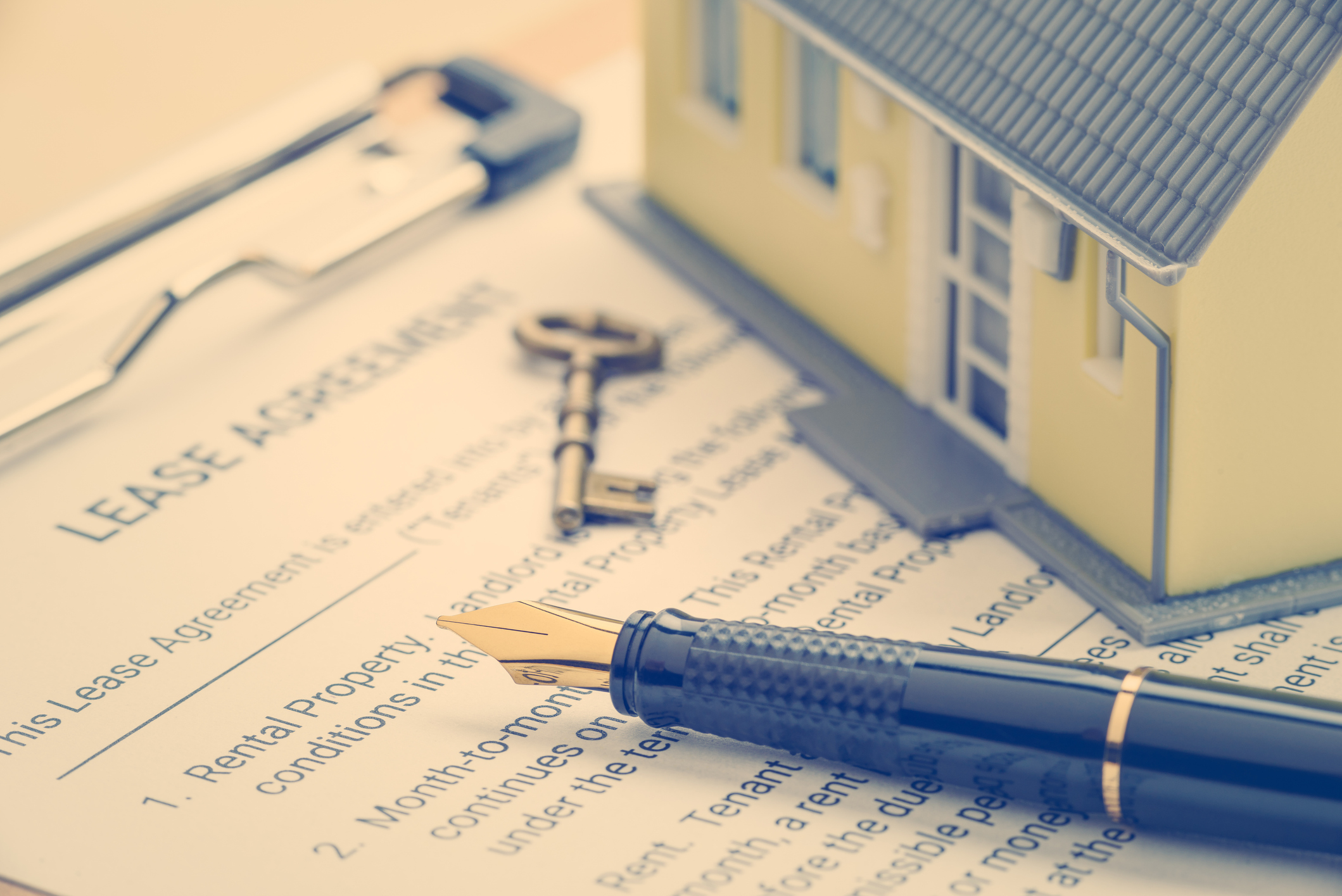 Business legal document concept : Pen, key, a house on a lease agreement form. Lease agreement is a contract between a lessor and a lessee that allow lessee rights to use of a property owned by lessor